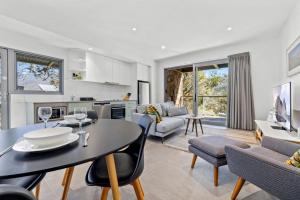 Una cocina y una sala de estar con mesa y sillas. en Little Rocky Retreat, en Perisher Valley