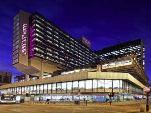 a large building with a sign on it at night at Mercure Manchester Piccadilly Hotel in Manchester