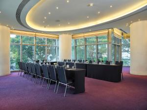 a large room with tables and chairs and windows at Pullman Saigon Centre in Ho Chi Minh City
