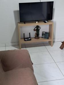 a television sitting on a stand in a living room at Chalé aconchegante à 300mts do mar in Arroio do Silva