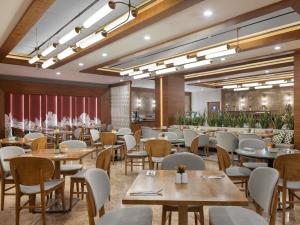 a restaurant with tables and chairs in a room at Mercure Ankara Kızılay in Ankara