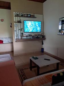 a living room with a tv and a coffee table at Casadaleila in Conceição do Mato Dentro