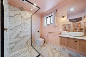 a bathroom with a shower and a toilet and a sink at Estelles Place by Discover Stradbroke in Amity Point +13 photos