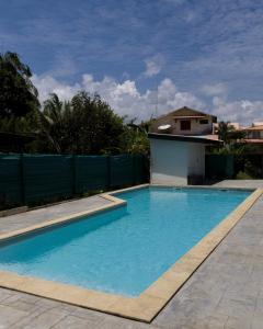 Una piscina con agua azul en un patio. en Cocon Montabo - logement tout équipé avec climatisation et Wi-Fi - à seulement 5 min de la plage, en Cayenne