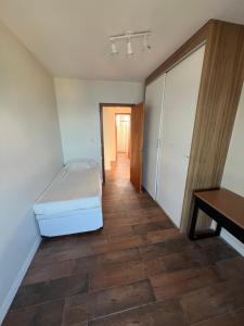 a bedroom with a bed and a desk in it at Refúgio Vista Mar Balneário Piçarras in Piçarras