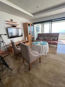 a living room with a couch and a table and chairs at Luxurious Seaside Apartment in Sidi Bouqnadel