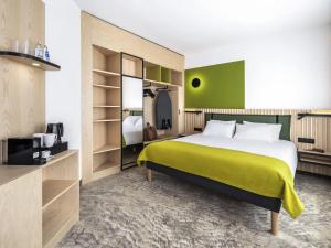 a bedroom with a large bed and a green wall at Mercure Katowice Centrum in Katowice