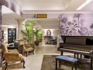 a living room with a piano and a table at Fairmont The Norfolk in Nairobi
