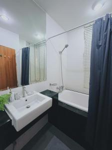 a bathroom with a sink and a bath tub and a sink at 10 minutes to reach the karon beach, with free swimming pool and gym, WIFI in Karon Beach