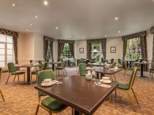 ソールズベリーにあるMercure Salisbury White Hart Hotel & Apartmentsのテーブルと椅子と窓のあるダイニングルーム