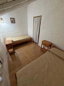 a room with two beds and a bench in it at Hostel Yara Yvera in Colonia Carlos Pellegrini