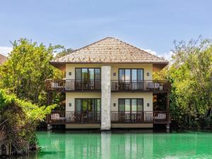 a house on top of a body of water at Fairmont Mayakoba in Playa del Carmen