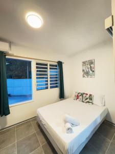 a bedroom with a bed and a window at Villa Alizé Kreyol in Le François