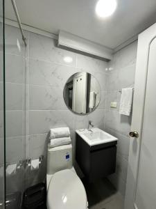 a bathroom with a toilet and a sink and a mirror at Hotel Lukas in Medellín