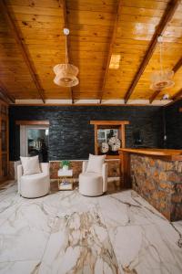 a living room with two chairs and a stone wall at Hotel Dorys de Lourdes in Pisco Elqui