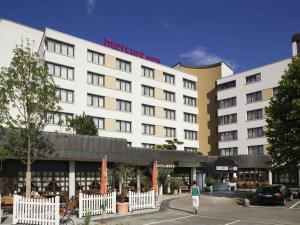 a woman walking in front of a hotel at Mercure Hotel am Messeplatz Offenburg in Offenburg