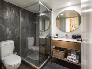 a bathroom with a toilet and a sink and a mirror at Mantra Terrace Brisbane in Brisbane