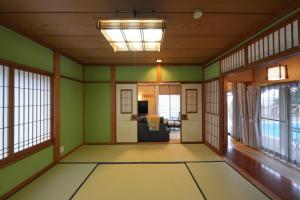 an empty room with green walls and windows at パーパスリゾート EG Sky terrace 熱川 in Higashiizu