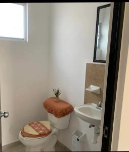 a bathroom with a toilet and a sink at Excelente hogar para descansar in Gómez