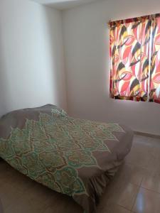 a bed in a corner of a room with a window at Excelente hogar para descansar in Gómez