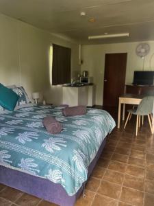 a bedroom with a bed and a kitchen and a table at Pandanus on Litchfield in Batchelor