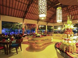 a restaurant with tables and chairs and lights at Novotel Bali Nusa Dua in Nusa Dua +119 photos