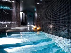 a swimming pool in a room with a brick wall at Sofitel Munich Bayerpost in Munich