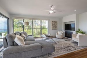 a living room with a couch and a tv at The Majestic Coolum Ocean Views & Poolside Escape in Coolum Beach