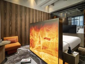 a hotel room with a bed and a large screen at The Emporium Hotel Plovdiv - MGallery Collection in Plovdiv +115 photos