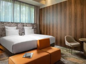 a bedroom with a bed and a table and a chair at The Emporium Hotel Plovdiv - MGallery Collection in Plovdiv