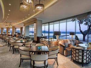 a hotel lobby with tables and chairs and windows at The Grand Tarabya Managed by Accor in Istanbul