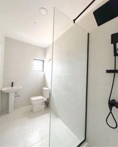 um banheiro com vaso sanitário e box de vidro em Anuoluwapo Taiwo Hotels em Lagos