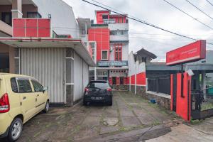 a car parked in a parking lot next to buildings at Wisma Vandera Syariah Garut Mitra RedDoorz in Garut