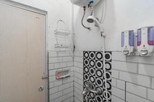a bathroom with a shower with a shower head at Wisma Vandera Syariah Garut Mitra RedDoorz in Garut +22 photos
