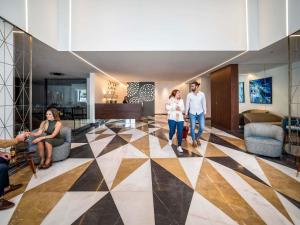 a group of people walking through a lobby at Mercure St. Julian's Malta in St Julian's