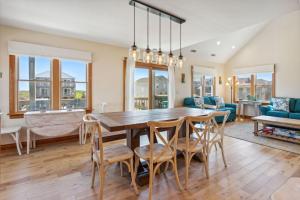 une cuisine et une salle à manger avec une table et des chaises en bois dans l'établissement 6002 - Cedar Sandcastle, à Croatan Shores