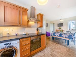 a kitchen with a washer and dryer in a room at Adderstone Folly in Belford