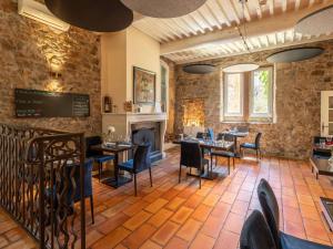 Un restaurante con mesas y sillas y chimenea. en Mercure Aix-En-Provence Sainte-Victoire, en Châteauneuf-le-Rouge