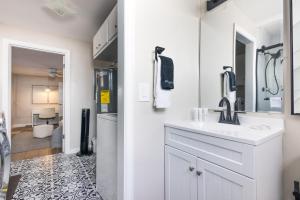 a white bathroom with a sink and a mirror at Biva Luxe in West Palm Beach +30 photos