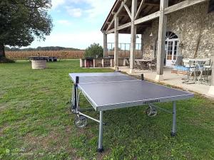 una mesa de ping pong frente a un edificio en Mansion in Fargues with Pool and Garden, en Fargues-sur-Ourbise