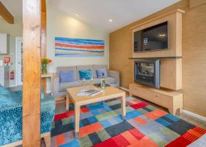a living room with a table and a tv at Brockwood Hall Lodges in Silecroft +108 photos