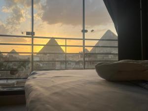 a bedroom with a large window with a view of pyramids at Continental Pyramids Terrace Hotel in Cairo