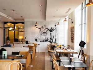 a restaurant with a picture of a cow on the wall at Mercure Bordeaux Centre Gare Atlantic in Bordeaux