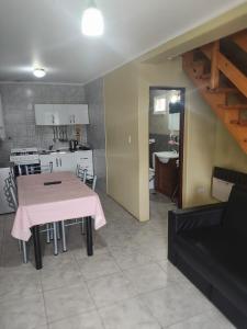 Una cocina y un comedor con una mesa y una cocina. en Apartamento 7, en El Calafate