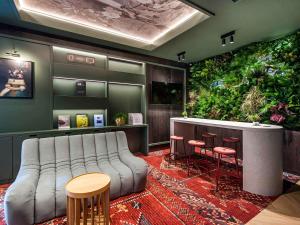 a living room with a couch and stools at Mercure Bialystok in Białystok