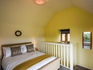 una camera da letto con un letto con pareti gialle e una finestra di Shropshire Way Stay a Farden