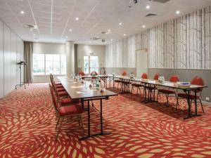 una sala conferenze con tavoli e sedie su un tappeto rosso di Mercure Rambouillet Relays Du Château a Rambouillet