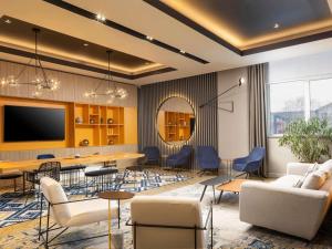 a living room with a table and chairs and a tv at Mercure Sibiu Airport in Sibiu