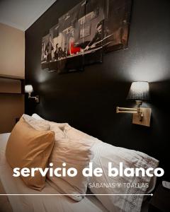 a bedroom with a bed and pictures on the wall at Depto Boutique Chivilcoy in Chivilcoy