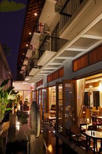 un restaurante con mesas y sillas por la noche en Villa Damar Boutique Hotel, en Bandung